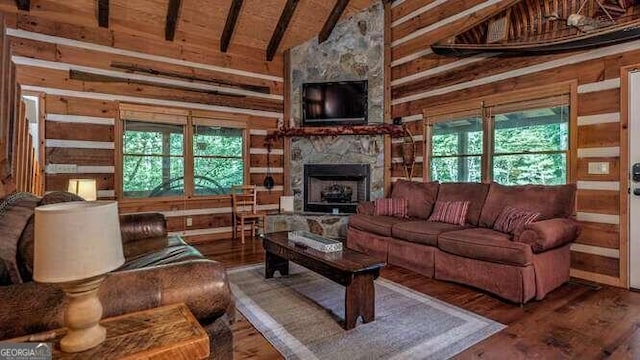 living room featuring a fireplace, beamed ceiling, plenty of natural light, and high vaulted ceiling