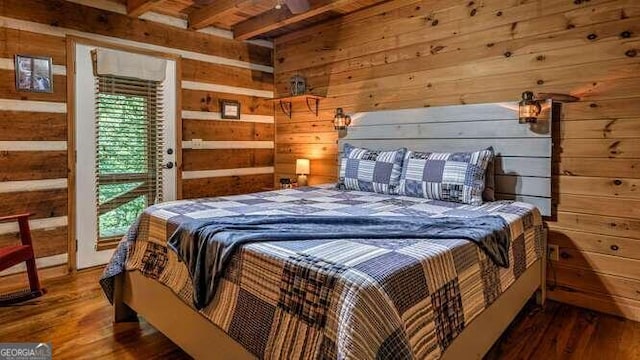 bedroom with wood walls and hardwood / wood-style flooring