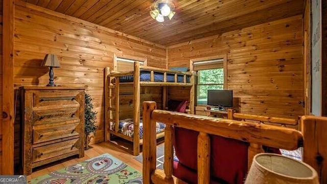 bedroom with wood walls, light wood-type flooring, and wooden ceiling