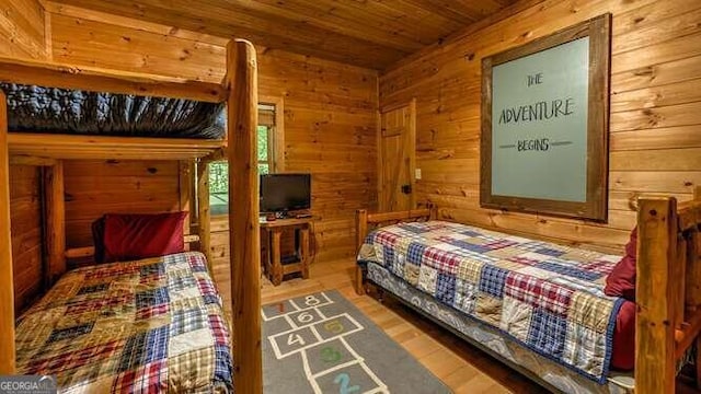 bedroom with wood walls, wood-type flooring, and wooden ceiling