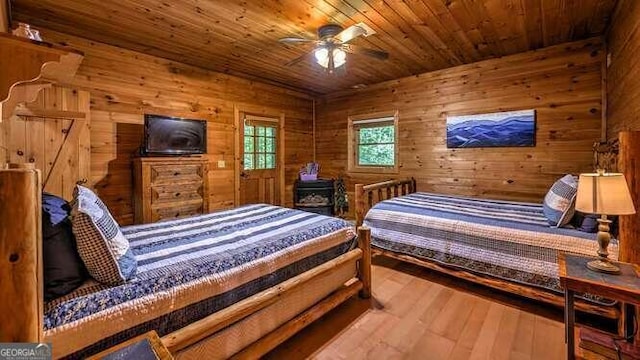 bedroom featuring wood walls, ceiling fan, hardwood / wood-style flooring, and wooden ceiling