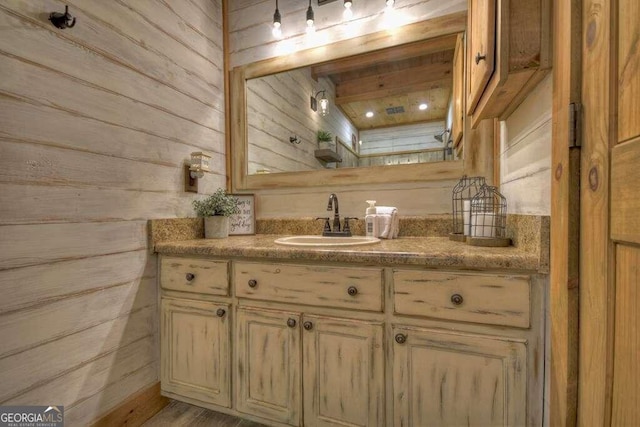 bathroom with wood walls, hardwood / wood-style flooring, and vanity