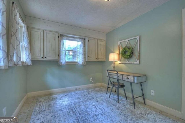 home office featuring light tile patterned floors and a textured ceiling