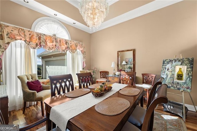 dining space with baseboards, a notable chandelier, wood finished floors, and ornamental molding