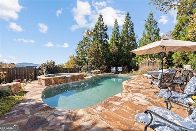 view of pool featuring a patio and an in ground hot tub