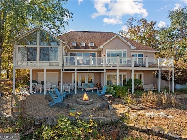 back of house with a deck, a patio, a garage, and an outdoor fire pit