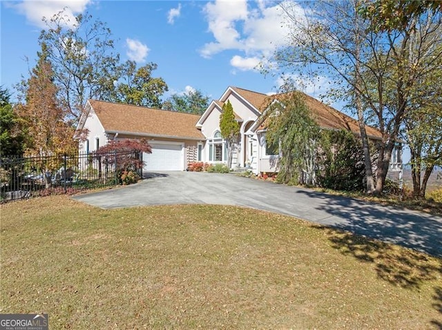 view of front of property featuring a front yard, fence, a garage, and driveway