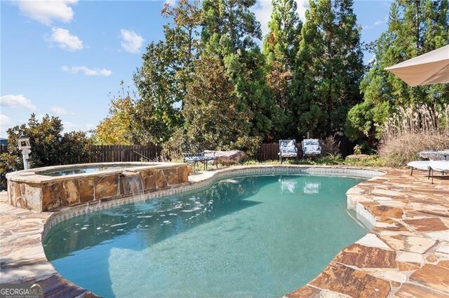 view of swimming pool featuring a patio area and an in ground hot tub