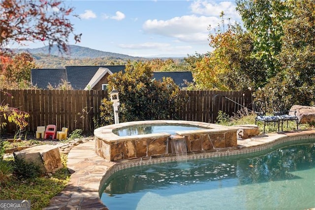 view of pool featuring a mountain view and an in ground hot tub