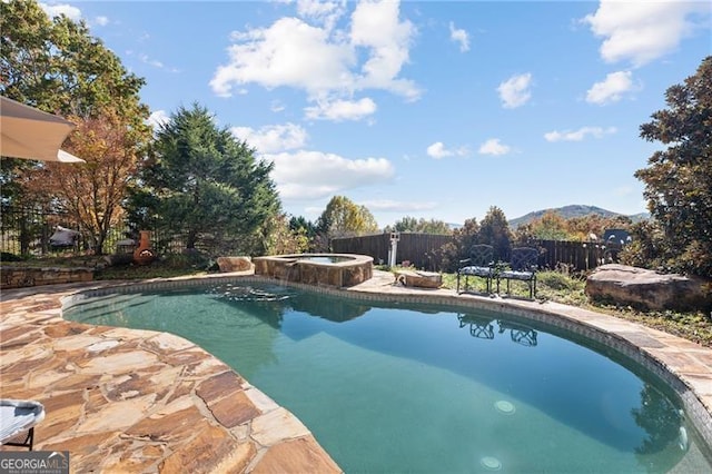 view of pool with an in ground hot tub and a mountain view