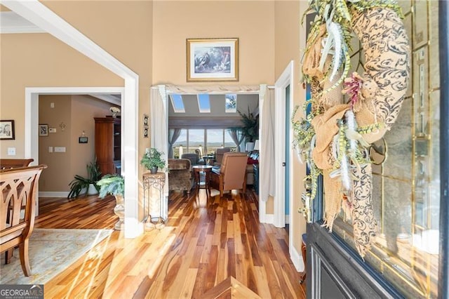 foyer entrance with wood-type flooring and crown molding