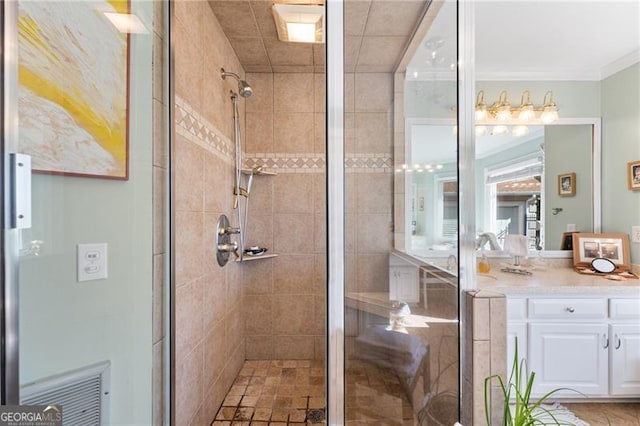 bathroom with ornamental molding, vanity, and a shower with shower door