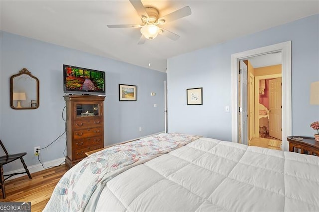 bedroom featuring light hardwood / wood-style flooring, connected bathroom, and ceiling fan