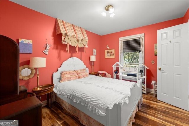 bedroom with dark wood-type flooring