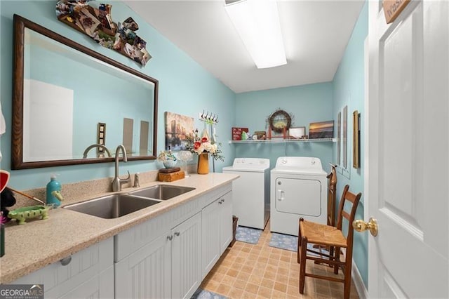 washroom with washing machine and dryer, cabinets, and sink