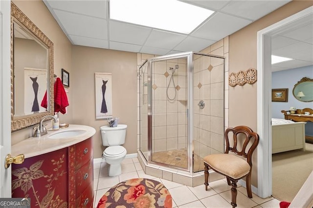 bathroom featuring vanity, toilet, walk in shower, and a drop ceiling