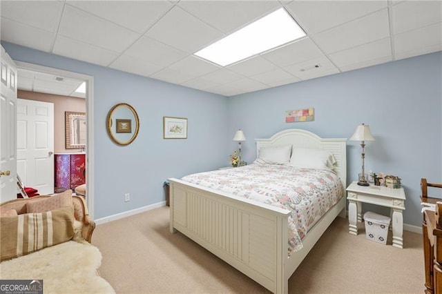 carpeted bedroom with a paneled ceiling