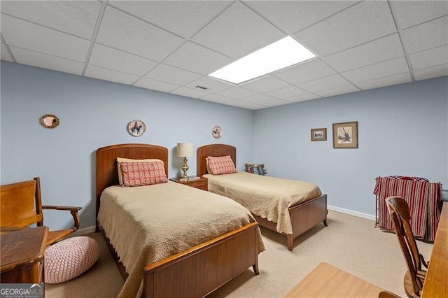 bedroom with a paneled ceiling and light carpet