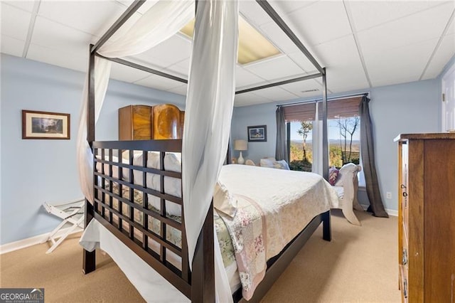 bedroom featuring light carpet and a paneled ceiling