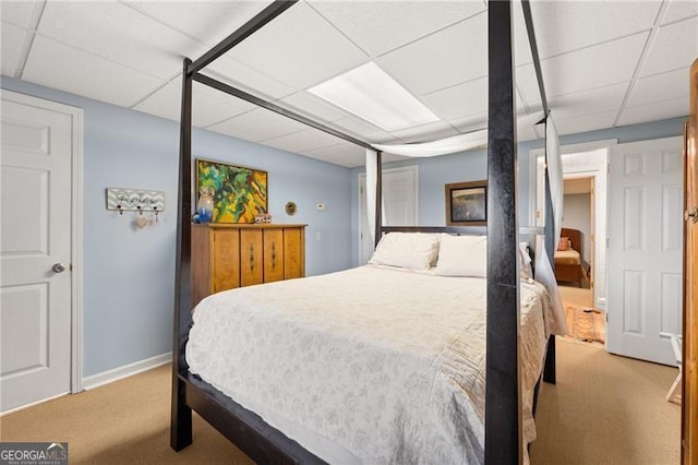 carpeted bedroom with a paneled ceiling