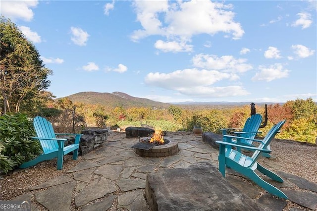 view of patio with a fire pit and a mountain view