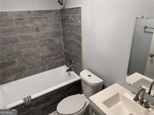 full bathroom with tiled shower / bath, toilet, and vanity