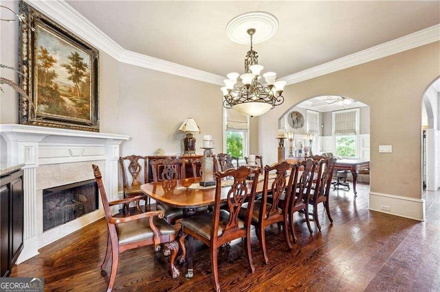 dining space featuring crown molding, plenty of natural light, an inviting chandelier, and dark hardwood / wood-style floors