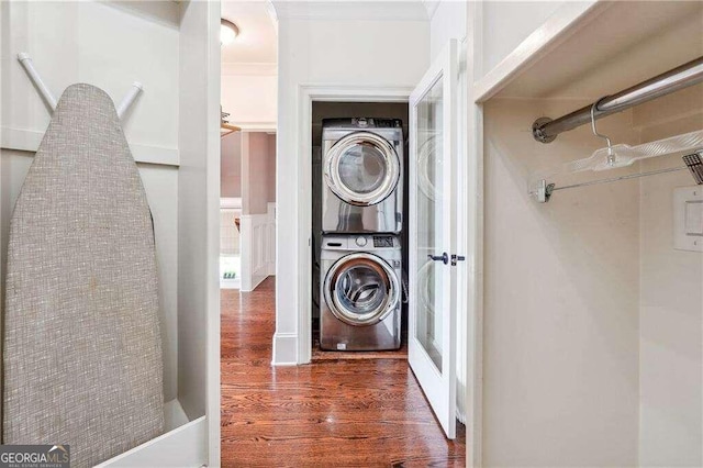 washroom featuring dark hardwood / wood-style flooring and stacked washer and dryer