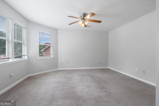 spare room featuring ceiling fan and carpet floors