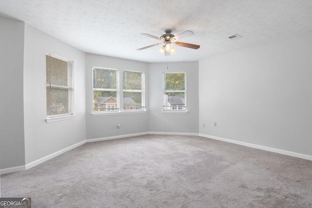 unfurnished room featuring ceiling fan, carpet, and a textured ceiling