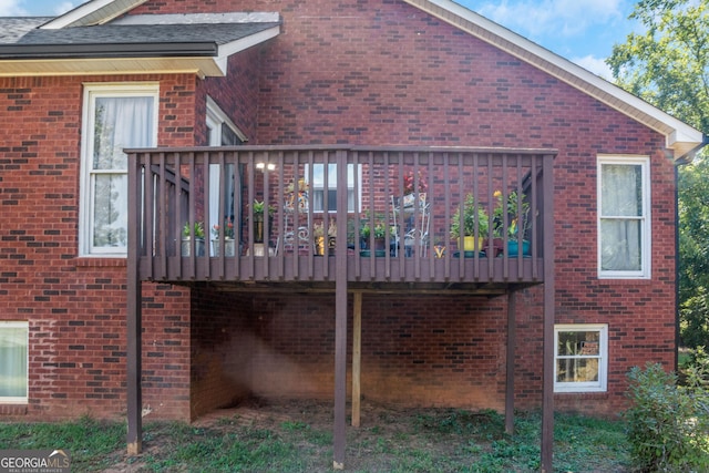 view of side of property with brick siding and a deck