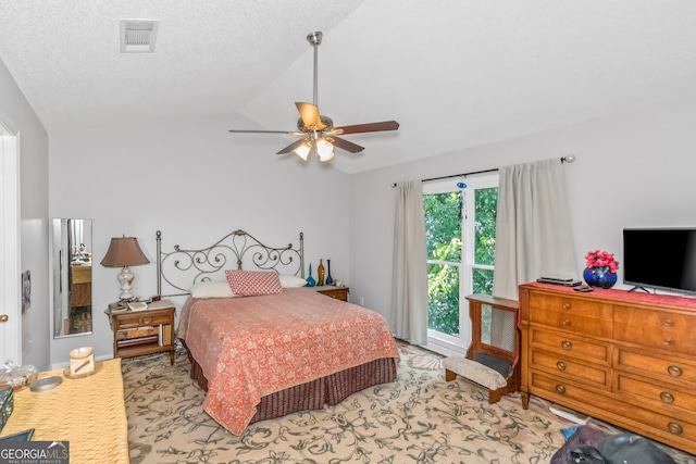 bedroom featuring lofted ceiling, ceiling fan, light colored carpet, and a textured ceiling