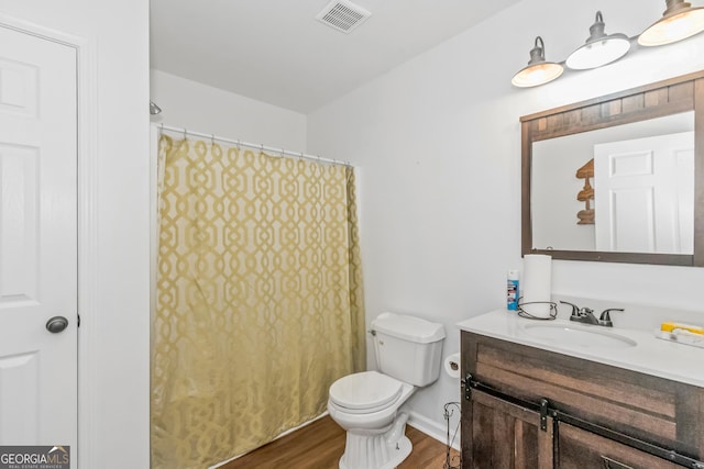 full bath featuring wood finished floors, toilet, vanity, and curtained shower