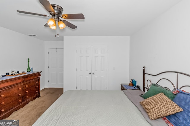 carpeted bedroom featuring a closet and a ceiling fan