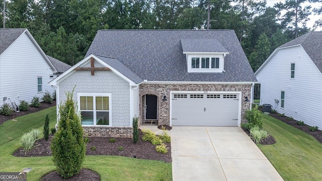 view of front of home featuring a garage, central AC unit, and a front lawn