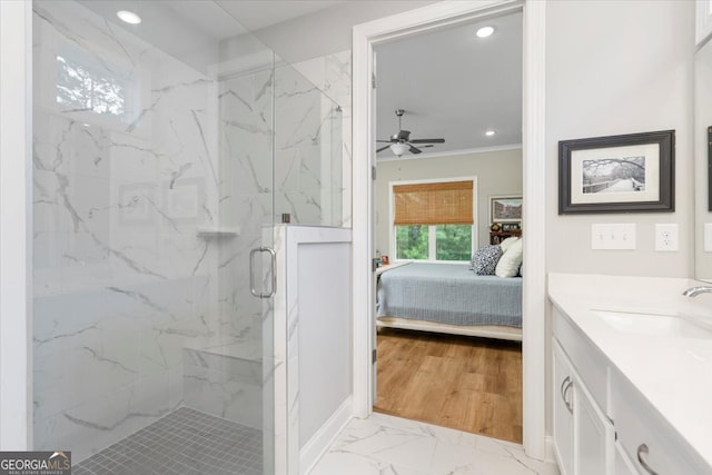 bathroom with a shower with door, crown molding, wood-type flooring, ceiling fan, and vanity