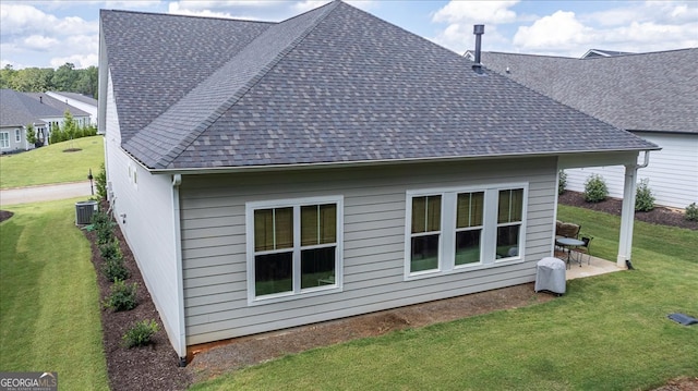 rear view of property with central AC and a lawn