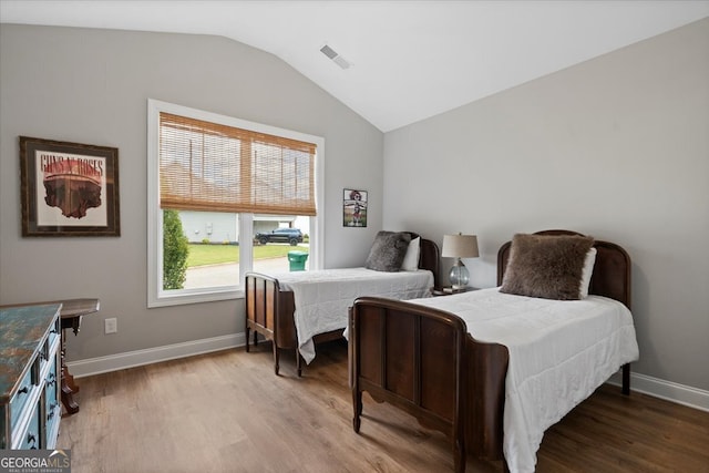 bedroom with lofted ceiling and wood-type flooring