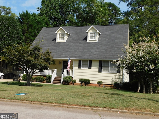 cape cod home with a porch and a front lawn