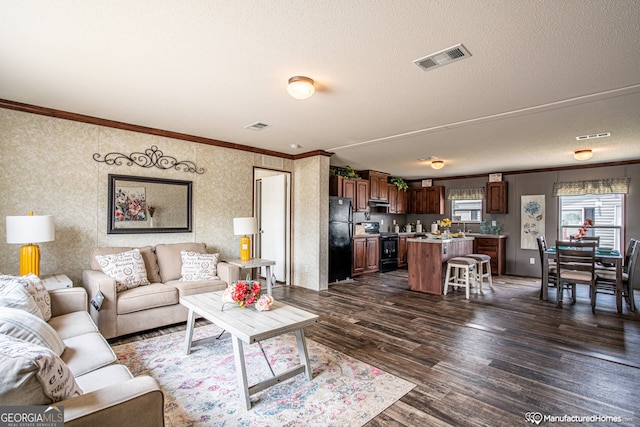 living room with ornamental molding, dark wood-type flooring, and a textured ceiling