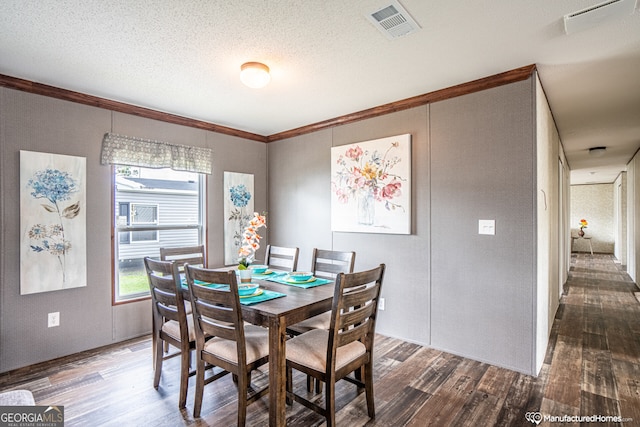 dining area with a textured ceiling, crown molding, and dark hardwood / wood-style flooring