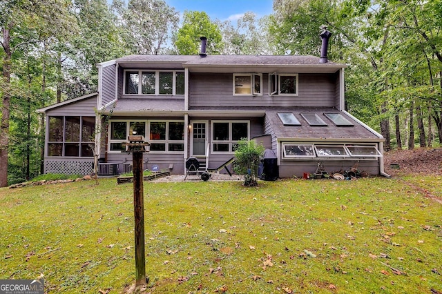 rear view of property with a sunroom and a lawn