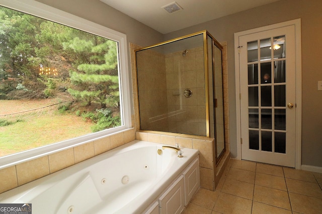 bathroom with separate shower and tub, a wealth of natural light, and tile patterned flooring