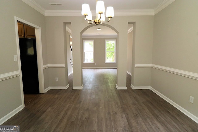 entrance foyer with dark wood-type flooring, an inviting chandelier, and ornamental molding