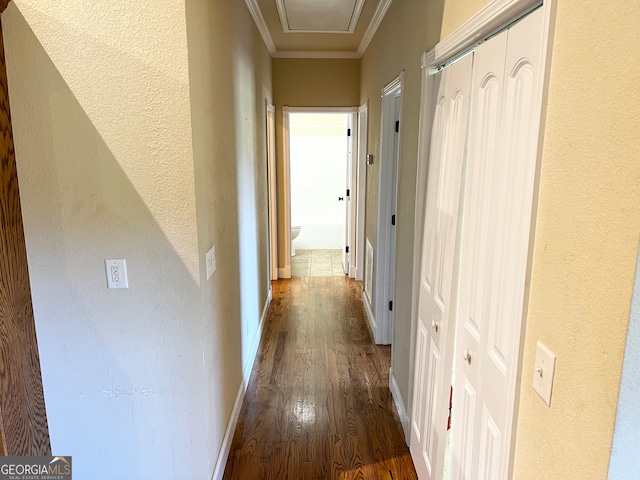 corridor with hardwood / wood-style floors and ornamental molding