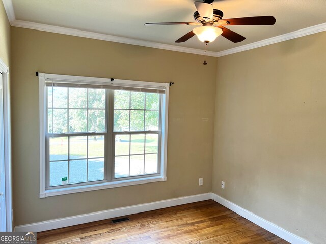 unfurnished room with hardwood / wood-style floors, ceiling fan, and crown molding