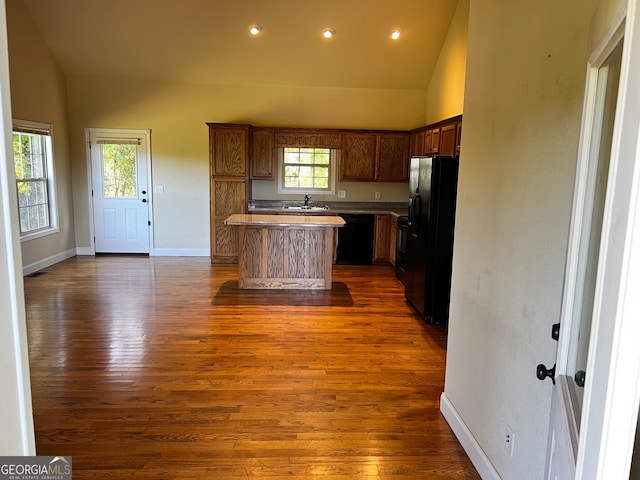 kitchen with black appliances, a center island, dark hardwood / wood-style floors, and a healthy amount of sunlight