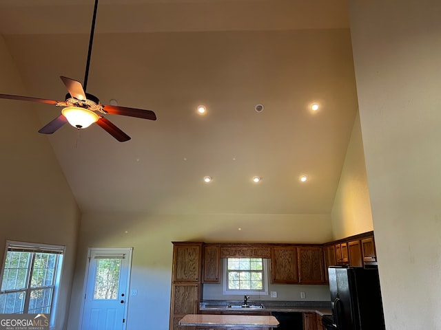 interior space with black appliances, ceiling fan, and sink