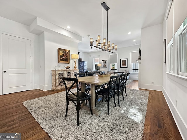 dining area with a notable chandelier and dark hardwood / wood-style flooring