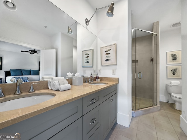 bathroom featuring a shower with door, tile patterned floors, toilet, ceiling fan, and vanity